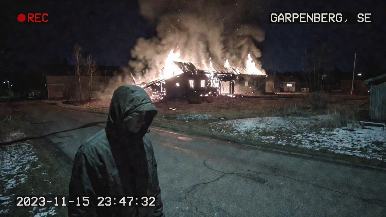 Grainy CCTV footage of a hooded person near a fire in Garpenberg for an arson news article.